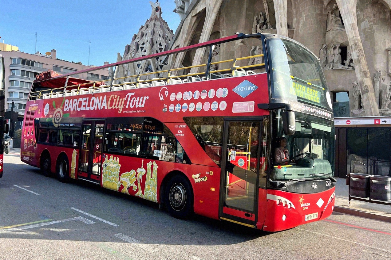 Roter Doppeldeckerbus einer Stadtrundfahrt vor der Sagrada Família in Barcelona